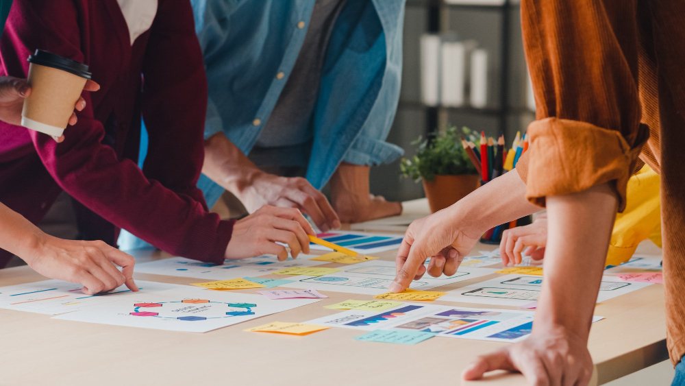 Volunteers planning together around a table covered in notes