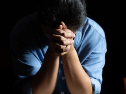 A woman praying over an open Bible